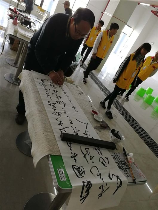 C:UsersAdministratorDesktop学校参加区技工院校啦啦操和书画比赛报道潘国兴老师在比赛中（书法） (2).jpg